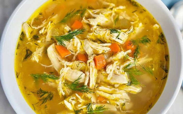 bowl of yellow soup with dill